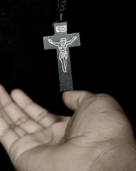 Mano abierta ante un crucifijo